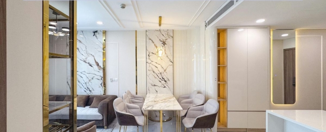 A modern condominium interior in Phuket featuring a marble dining table, upholstered chairs, and elegant gold accents. The space is bright and contemporary with clean lines and a luxurious finish. A banner across the top reads “Essential Tips for Buying a Condo in Phuket.”