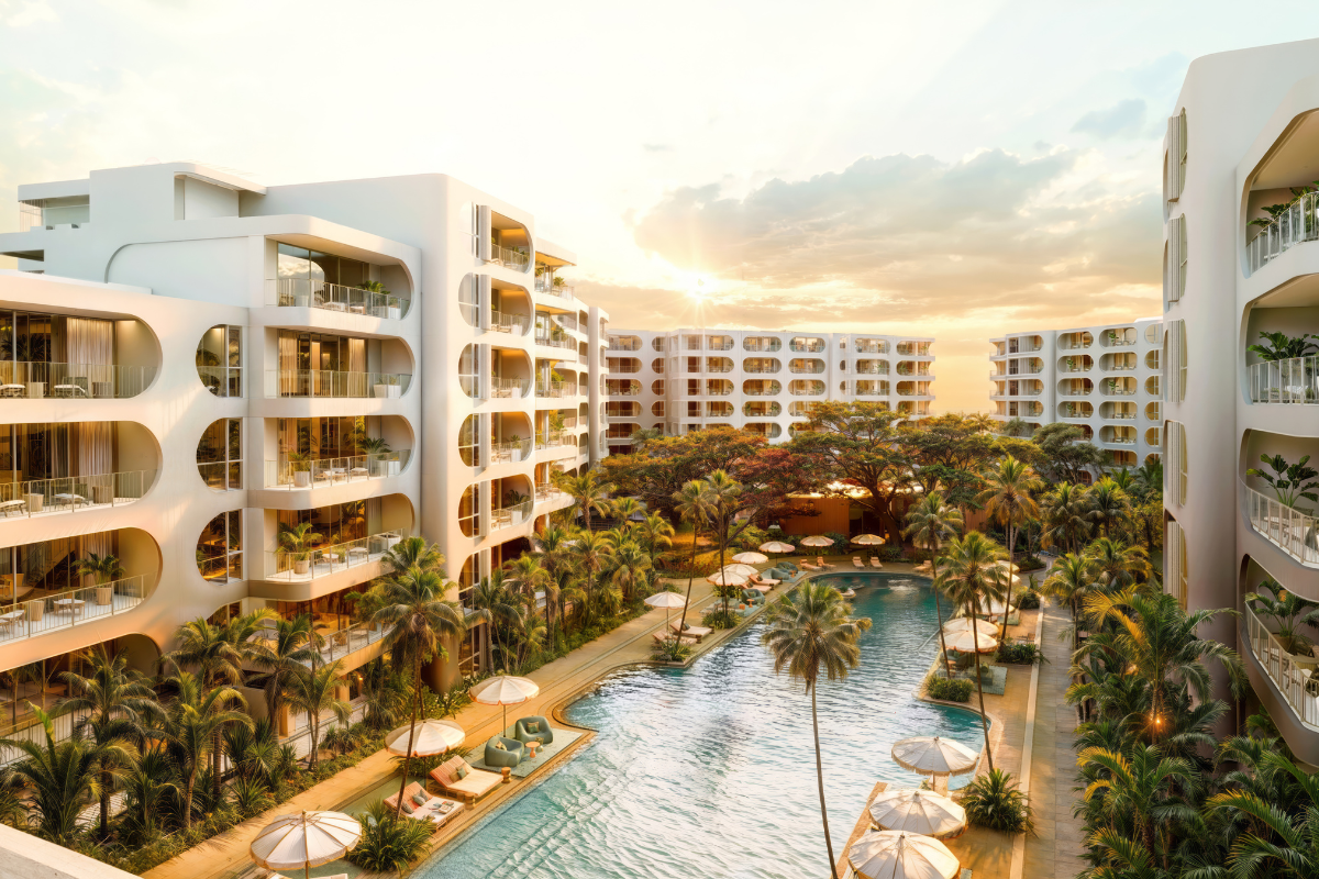 Exterior view of the standard residences in Phuket, modern low-rise building with clean architectural lines, surrounded by tropical landscaping and clear blue skies.