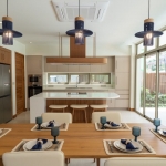 4-bedroom pool villas in Baan Manik, Phuket 6-seater dining table and kitchen with breakfast island front PSV-MNK-1267