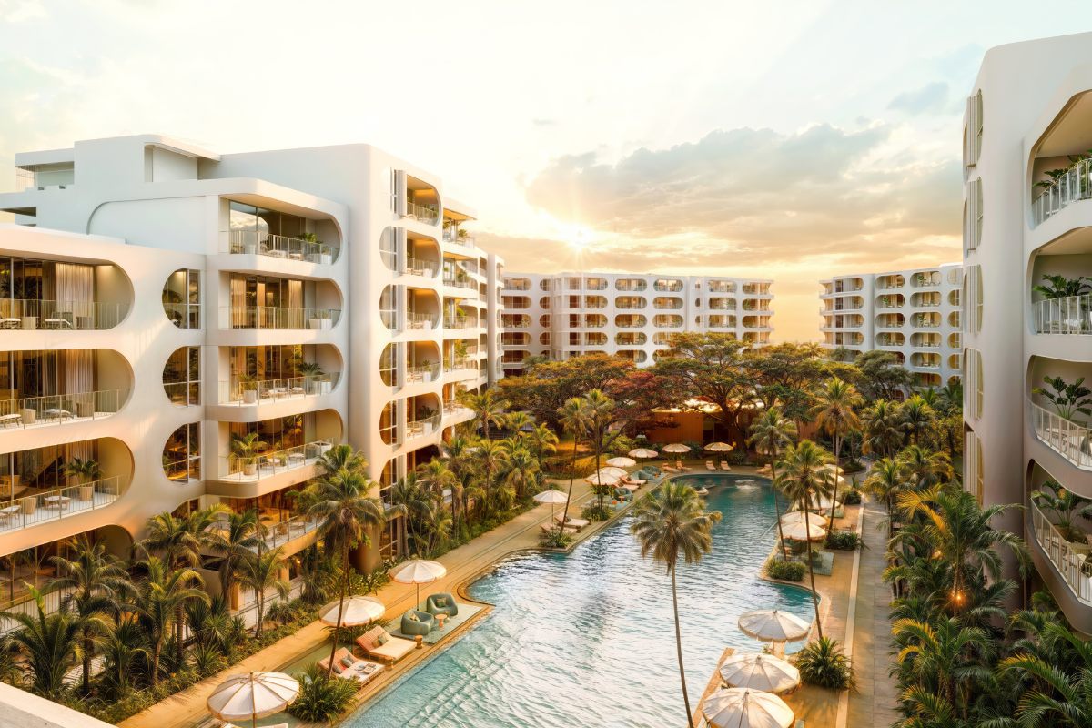 Exterior view of the standard residences in Phuket, modern low-rise building with clean architectural lines, surrounded by tropical landscaping and clear blue skies.