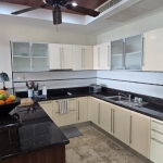 3-bedroom sea view condo near CoCo Pier in Panwa, Phuket u-shaped kitchen wtih white cabinets and black countertops PSC-PAN-1550