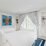 6-bedroom beachfront pool villa on Natai Beach, white bedroom with twin bed and blue rug PSV-PHA-1565