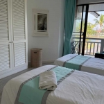 2-bedroom condo in Laguna Phuket all white twin bedroom with turquoise curtains and bed runner PSC-LAG-1598