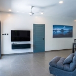 2-bedroom pool villa in Soi Naya, 5 minutes to Nai Harn Beach, Phuket gray chair facing tv and blue door PSV-NAH-1607