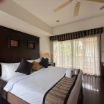3-bedroom pool villa directly beside the fairways in Laguna, Phuket bedroom with wooden headboard and balcony access PSV-LAG-1580
