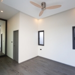 3-bedroom pool in Soi Samakki, Rawai, Phuket vacant room with white walls, ceiling fan and wall mirror PSV-RAW-1596