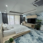 3-bedroom condo in Kamala, Phuket bedroom with light wood furniture, tv shelf and balcony PSC-KAM-1604